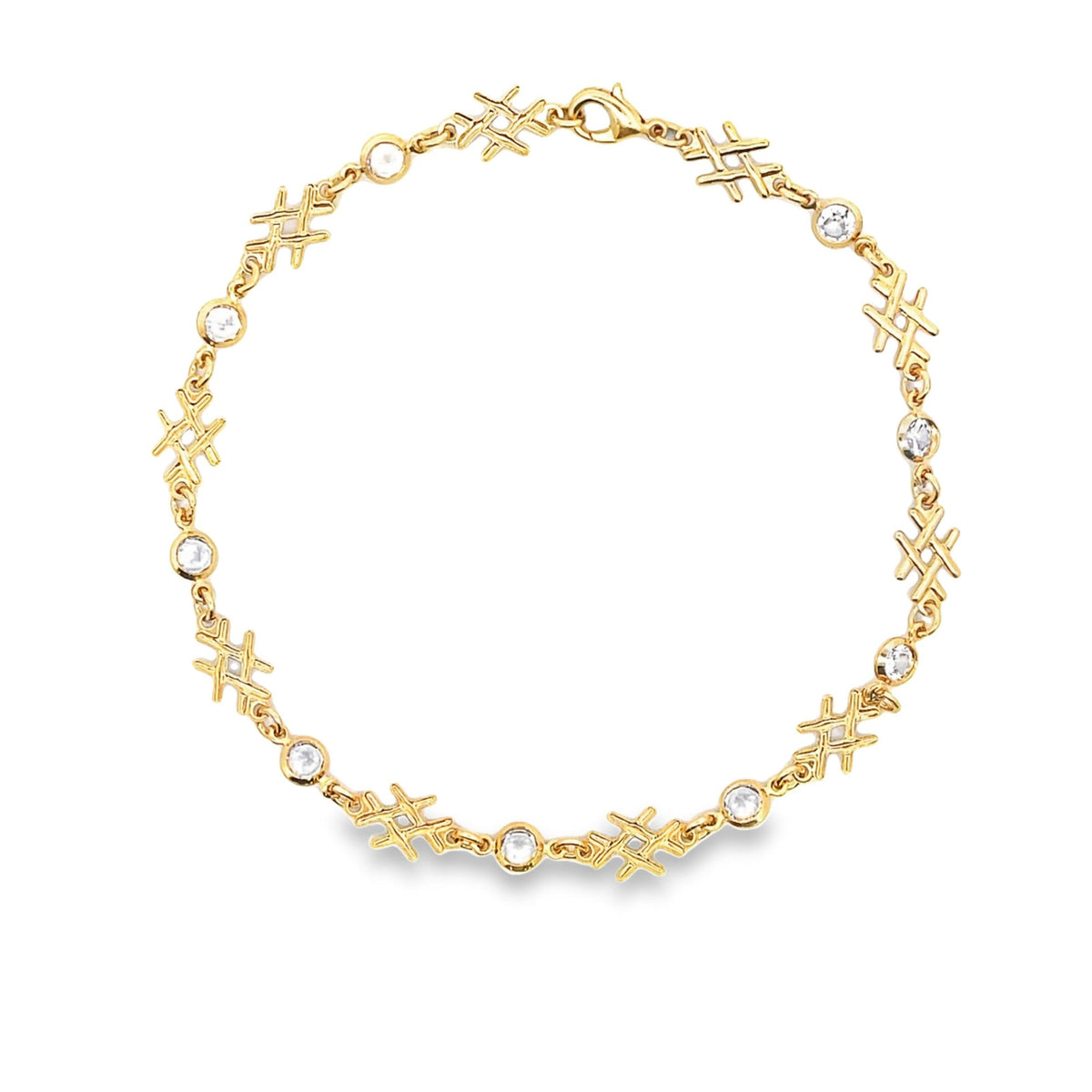 A delicate gold bracelet features alternating tic-tac-toe symbols and sparkling bezel-set diamonds arranged in a circle.
