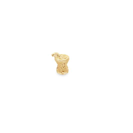A delicate gold cocktail glass charm with a tiny straw rests against a clean white background.