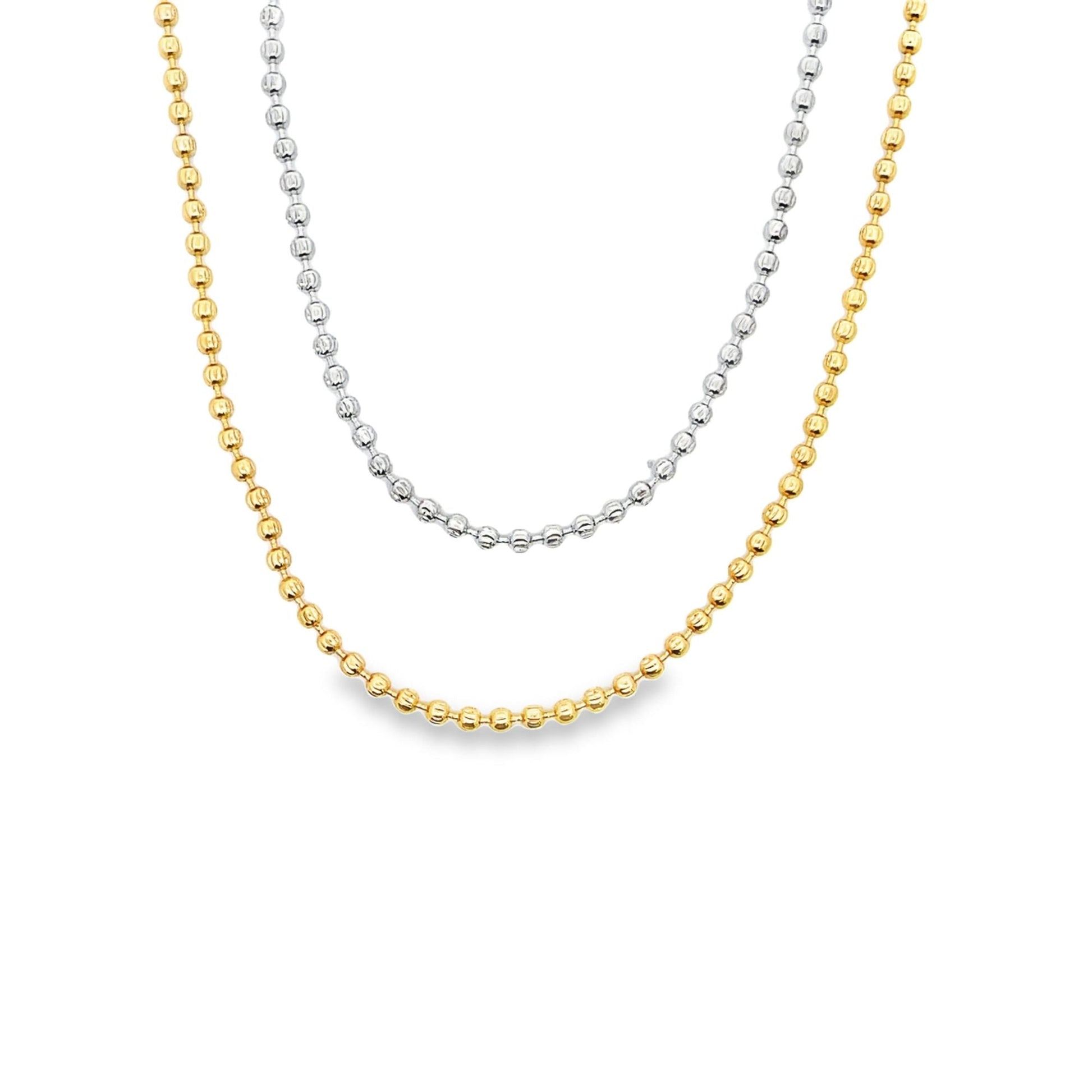 A layered gold and silver ball chain necklace rests gracefully against a clean white background.
