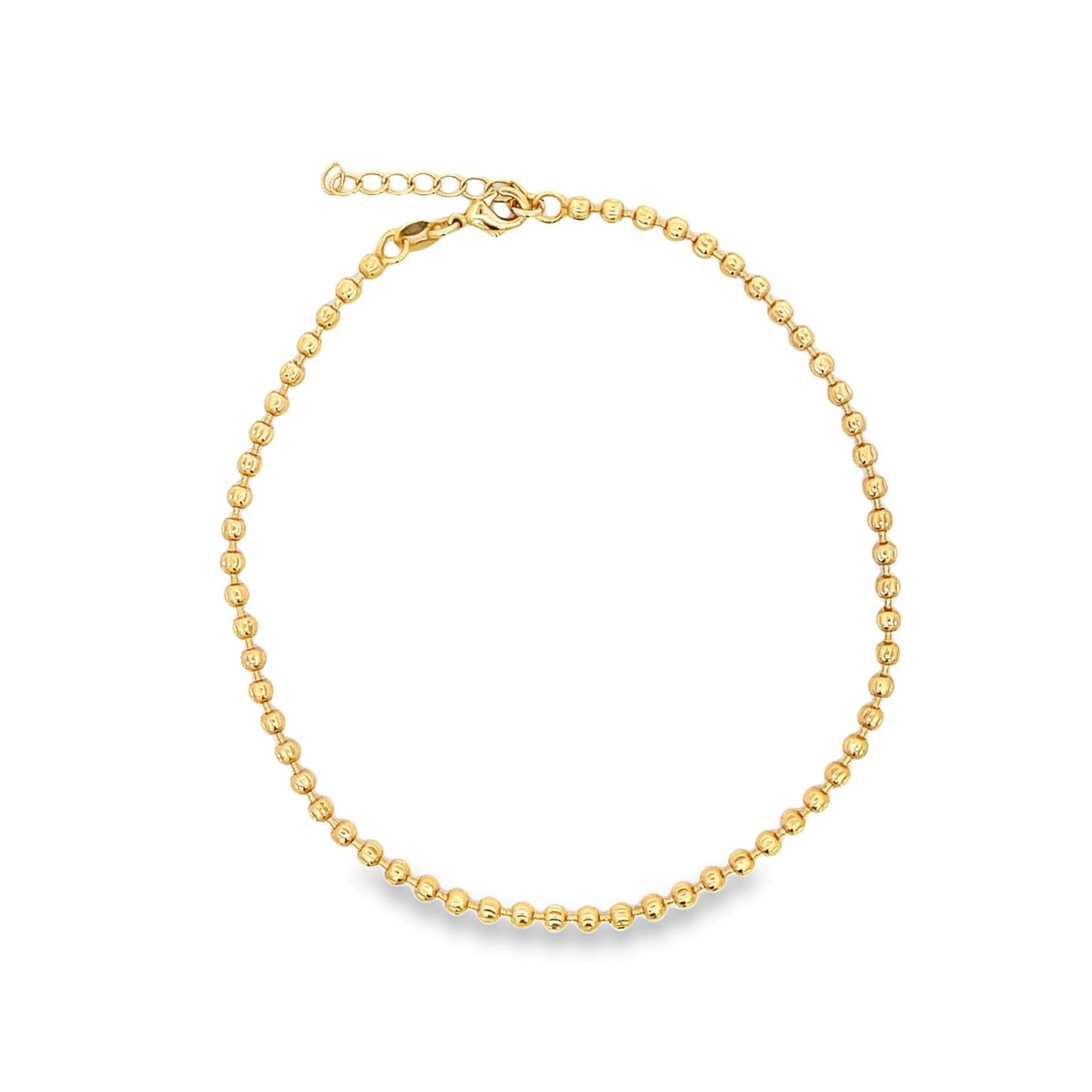A gold bead chain anklet rests in a complete circle on a clean white background.