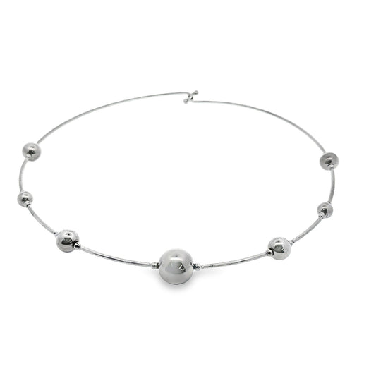 A sleek sterling silver omega necklace features a graduated series of polished spherical beads along its curved wire.