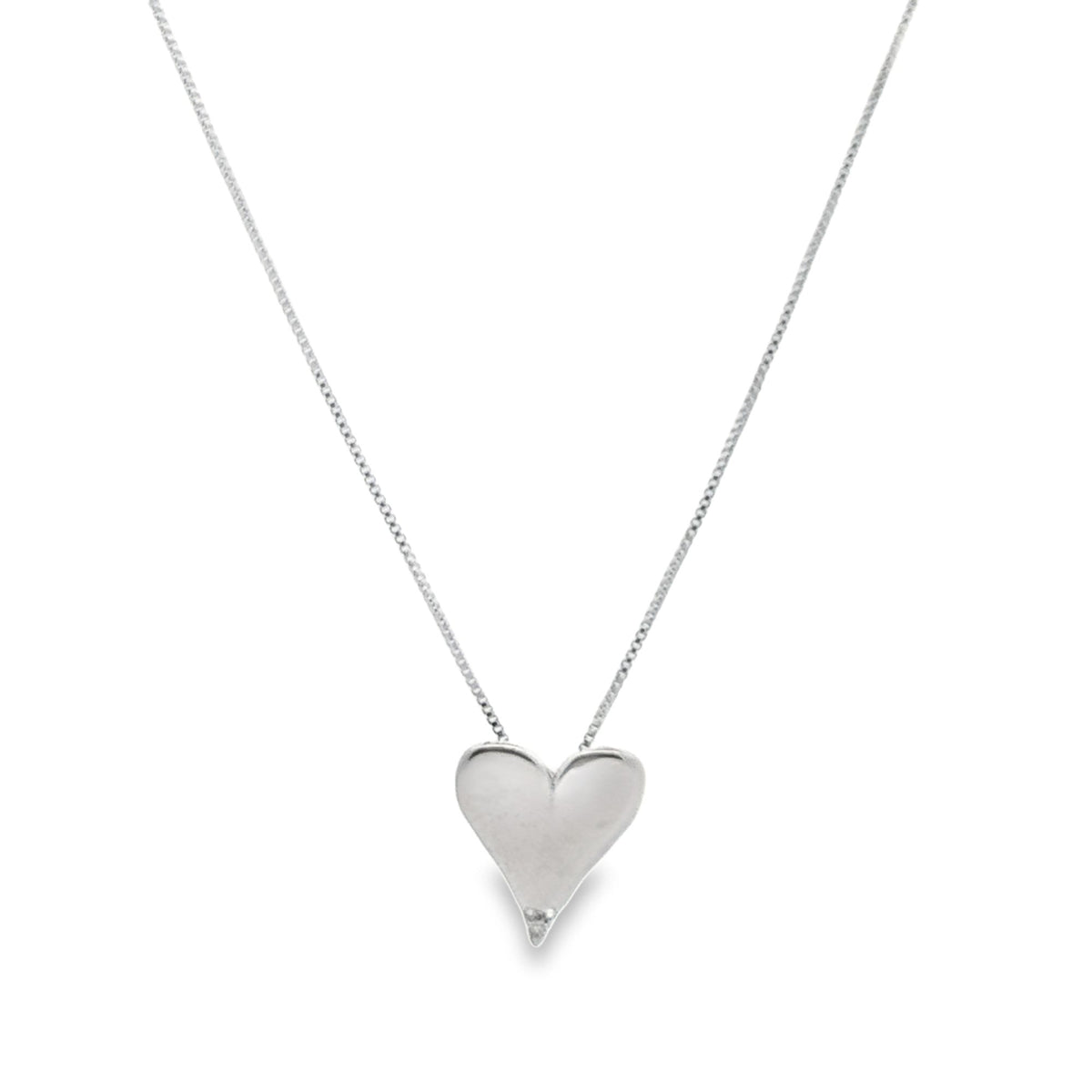 A delicate silver chain necklace features a polished heart-shaped pendant dangling at the center.