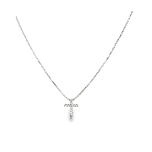 A delicate silver chain necklace features a sparkling diamond-paved cross pendant hanging against a plain white background.