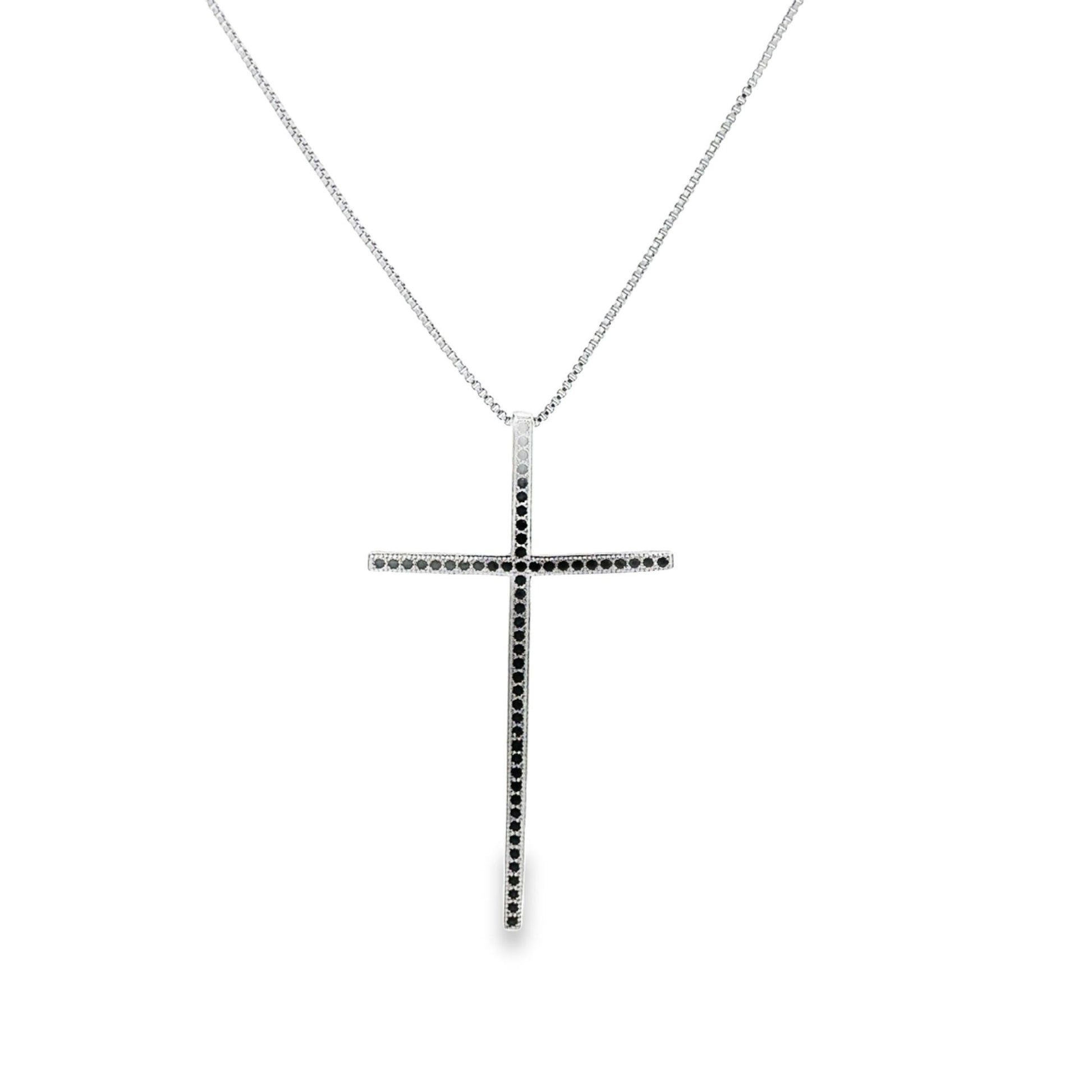 A silver cross pendant necklace encrusted with black diamonds hangs from a delicate box chain.