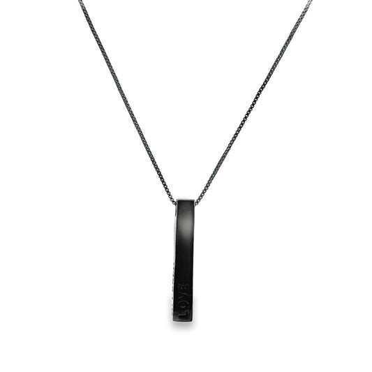 A sleek black bar pendant inscribed with the word "LOVE" hangs delicately from a matching dark chain necklace.