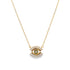 A delicate gold chain necklace features a sparkling evil eye pendant adorned with cubic zirconia crystals and green stones.
