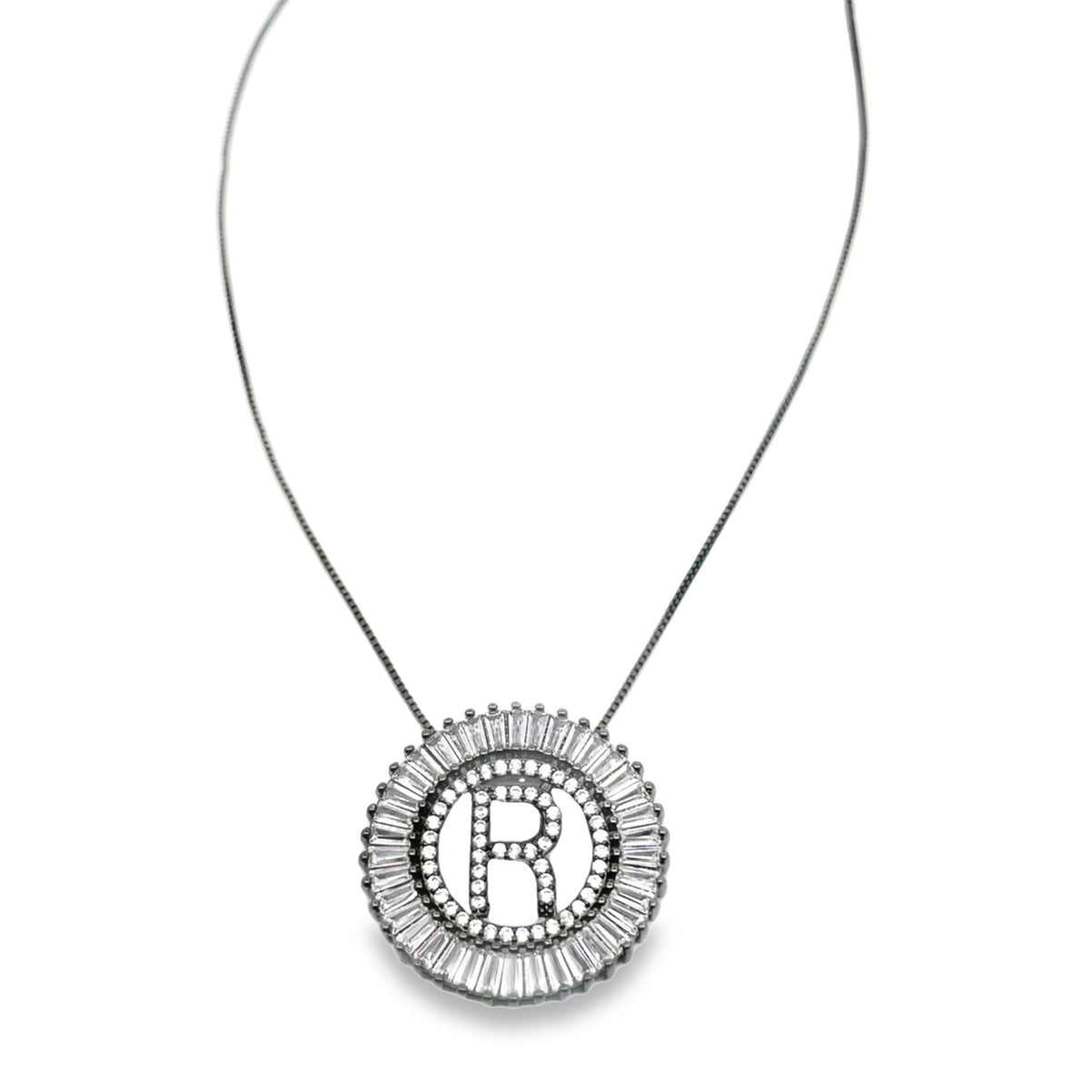 A sterling silver necklace features a round pendant embellished with sparkling cubic zirconia stones and a prominent initial R in the center.