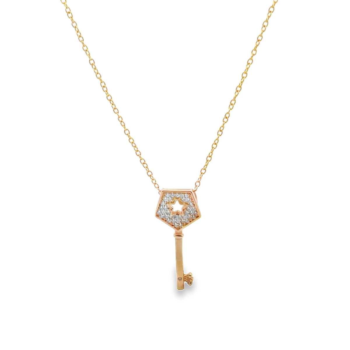 A delicate gold chain holds a diamond-encrusted key pendant with a star-shaped cutout.