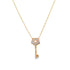 A delicate gold chain holds a diamond-encrusted key pendant with a star-shaped cutout.
