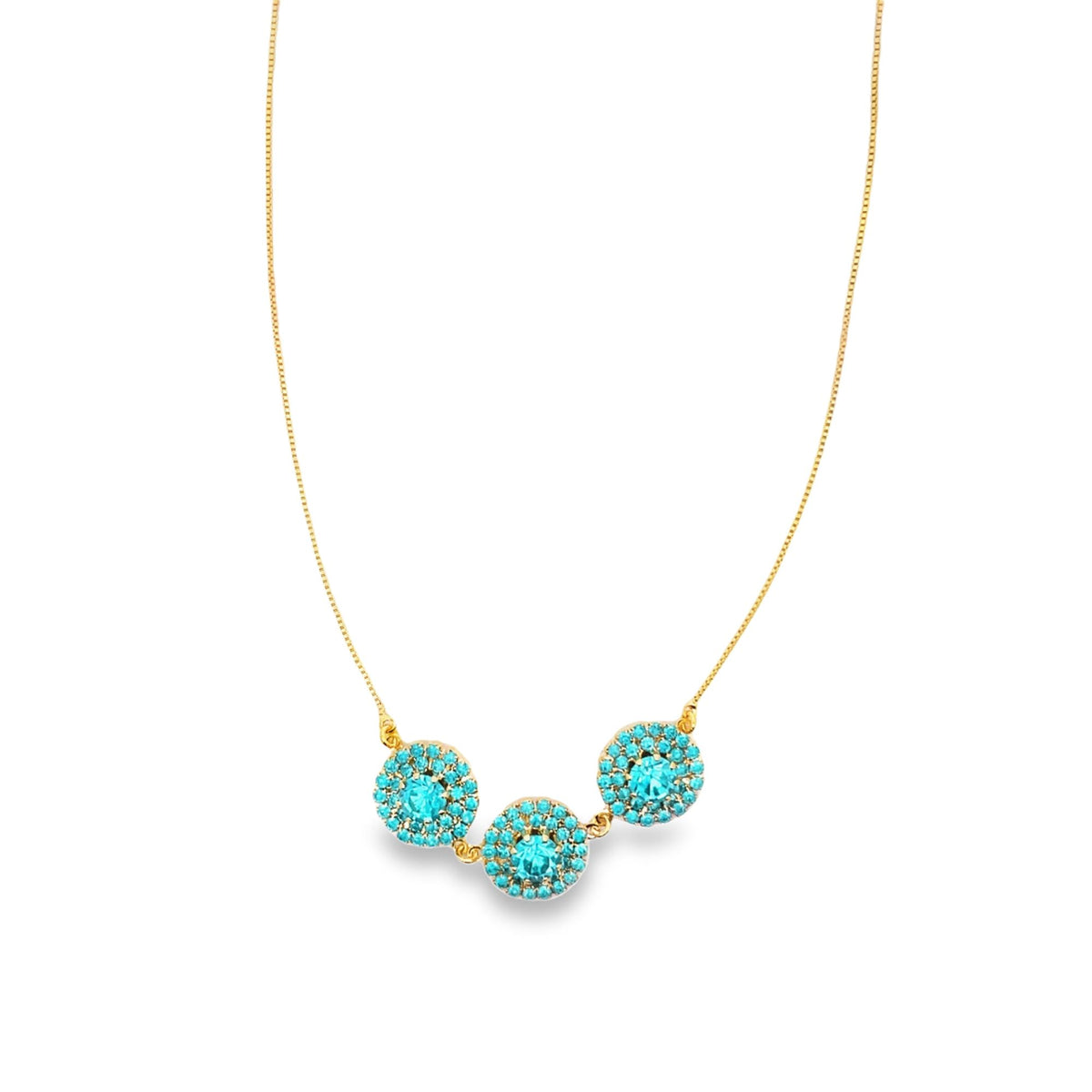 A delicate gold chain necklace features three sparkling turquoise crystal pendants.