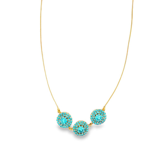 A delicate gold chain necklace features three sparkling turquoise crystal pendants.