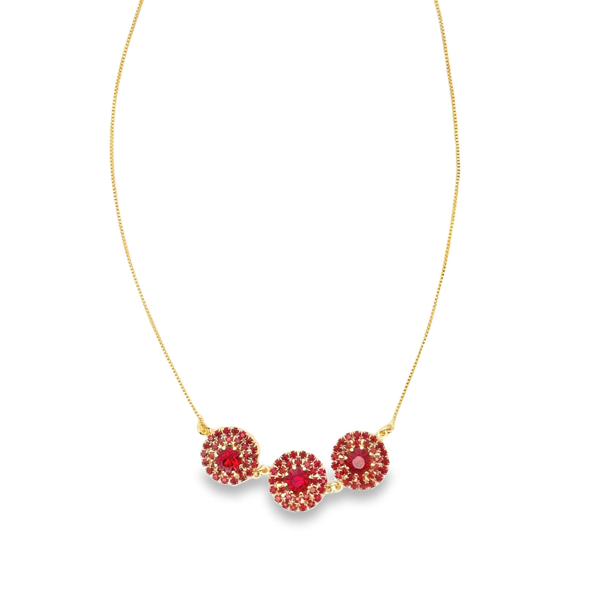A delicate gold chain necklace features three sparkling red crystal cluster pendants against a clean white background.