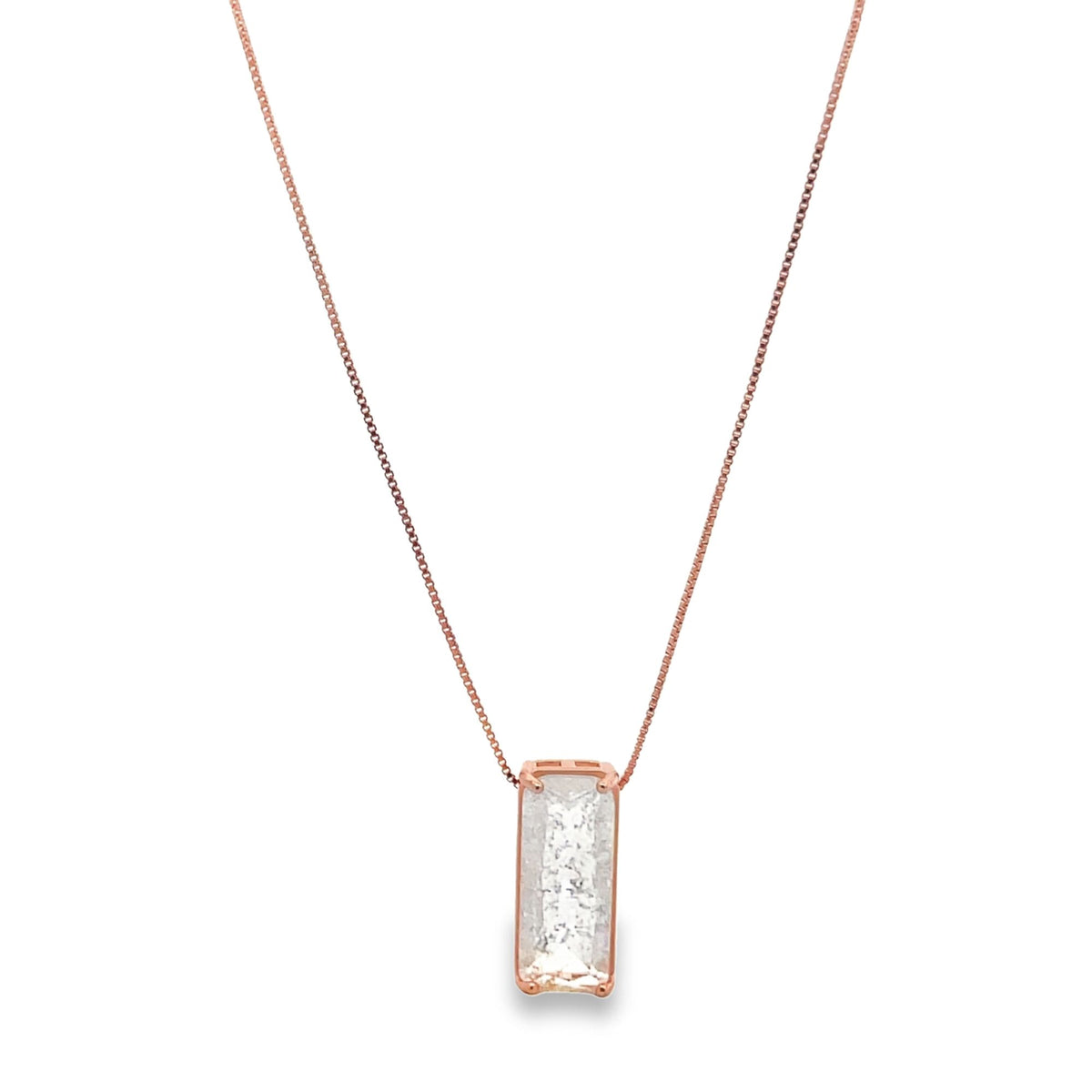 A delicate rose gold necklace features a rectangular emerald-cut diamond pendant hanging on a thin chain.