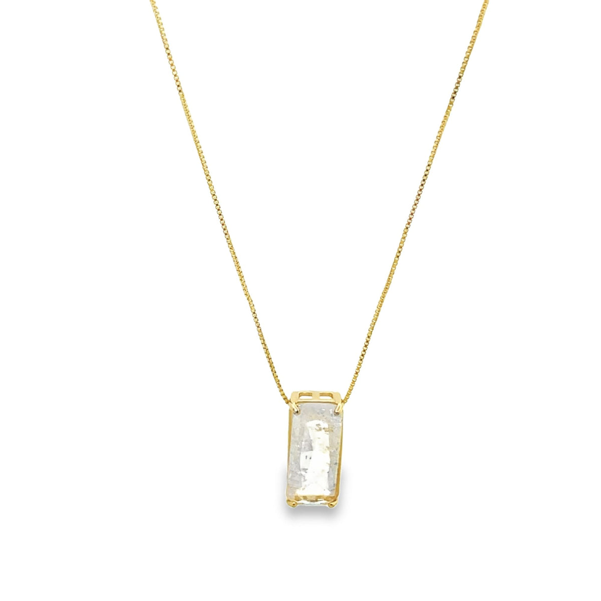A delicate gold chain necklace dangles an elegant rectangular pendant featuring a white crystal gemstone.