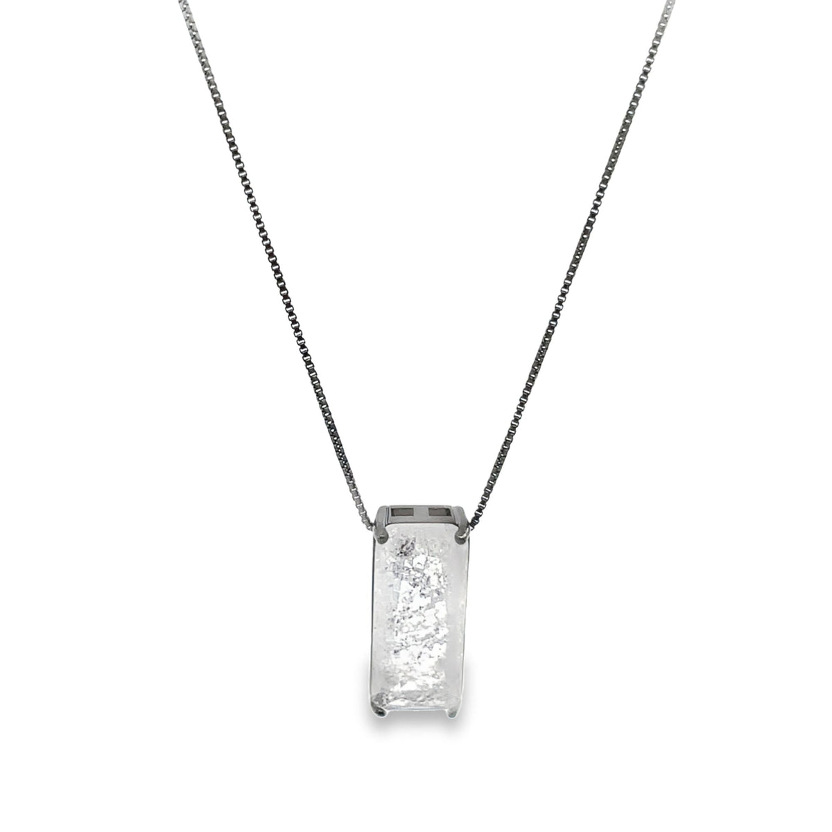 A delicate silver chain necklace features a rectangular pendant with a textured white gemstone against a plain white background.
