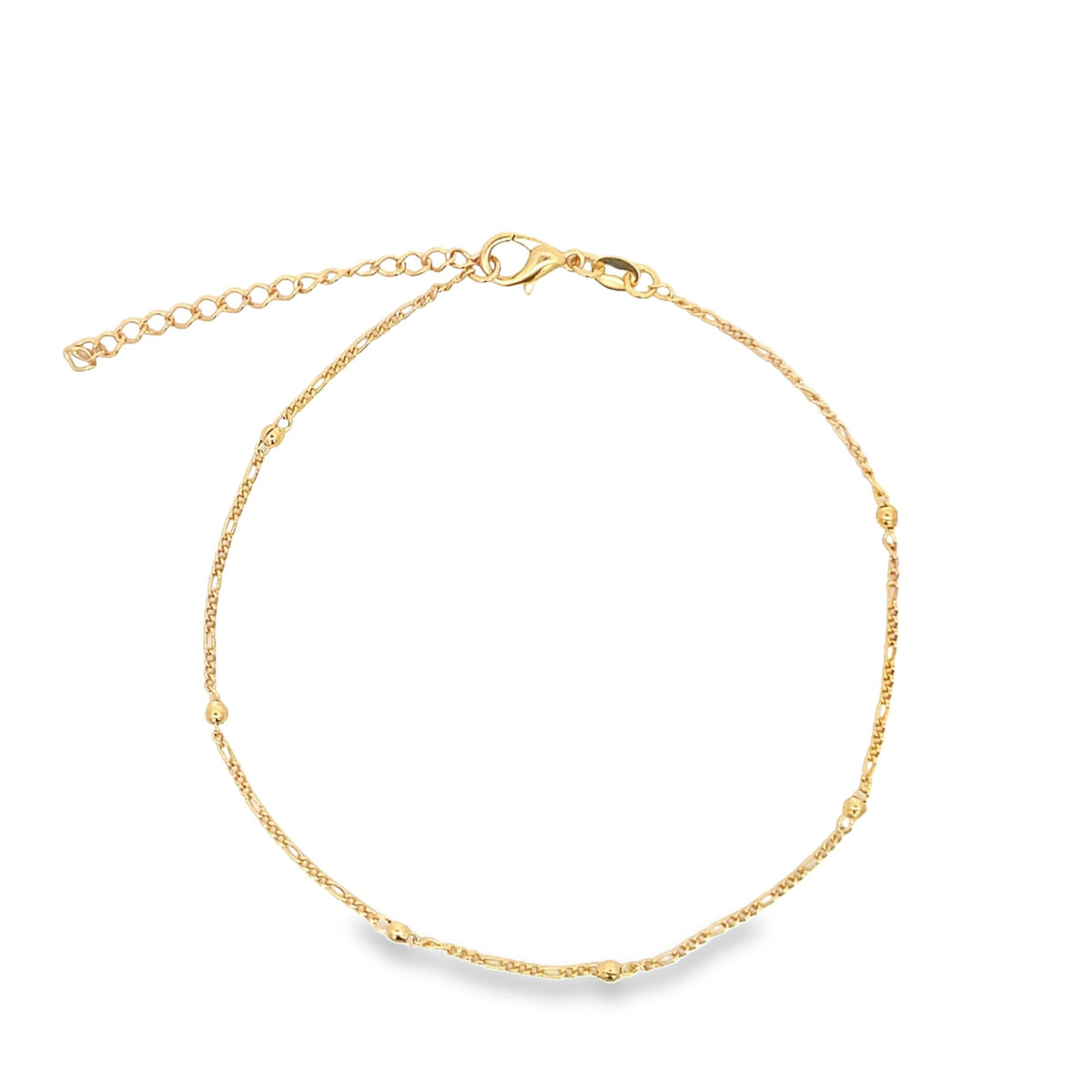 A delicate gold anklet featuring a fine chain accented with small beads and an adjustable clasp rests against a white background.