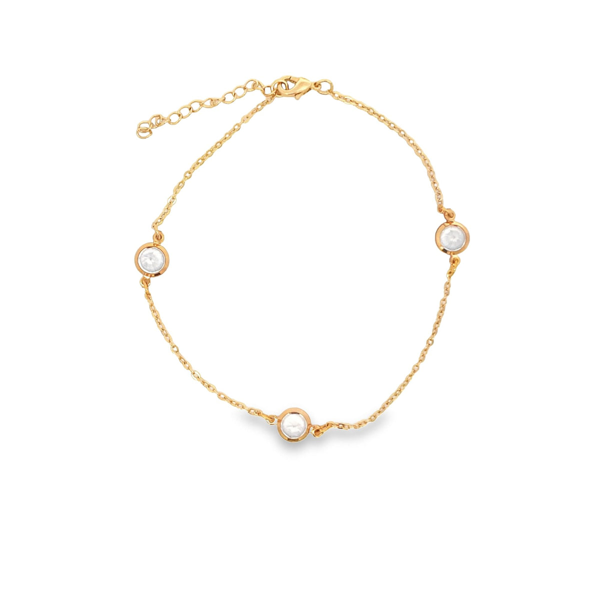 A delicate gold chain bracelet features three bezel-set round diamond charms displayed against a clean white background.