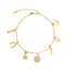 A gold charm bracelet displays various protective symbols including a hamsa, horseshoe, and money bag against a white background.