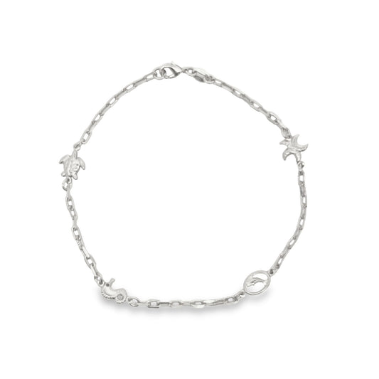 A delicate silver chain bracelet displays charming ocean-themed charms including a turtle, seahorse, and starfish.