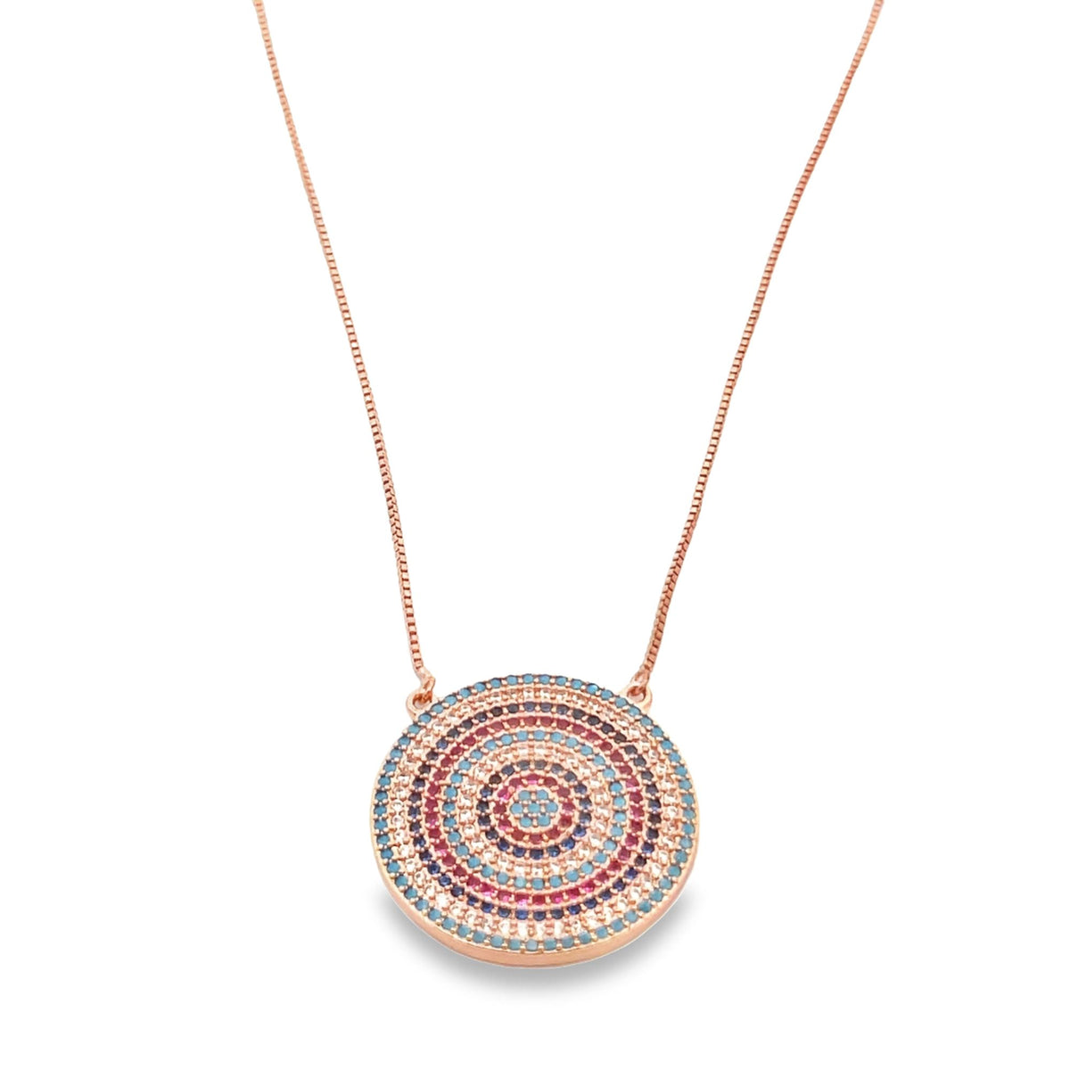 A rose gold pendant necklace hangs against a white background, featuring a circular medallion intricately set with concentric rings of multicolored cubic zirconia stones in shades of blue, pink, and white.