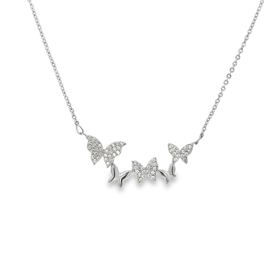 A delicate silver chain necklace features a cluster of sparkling, pavé-set diamond butterfly pendants suspended against a white background.
