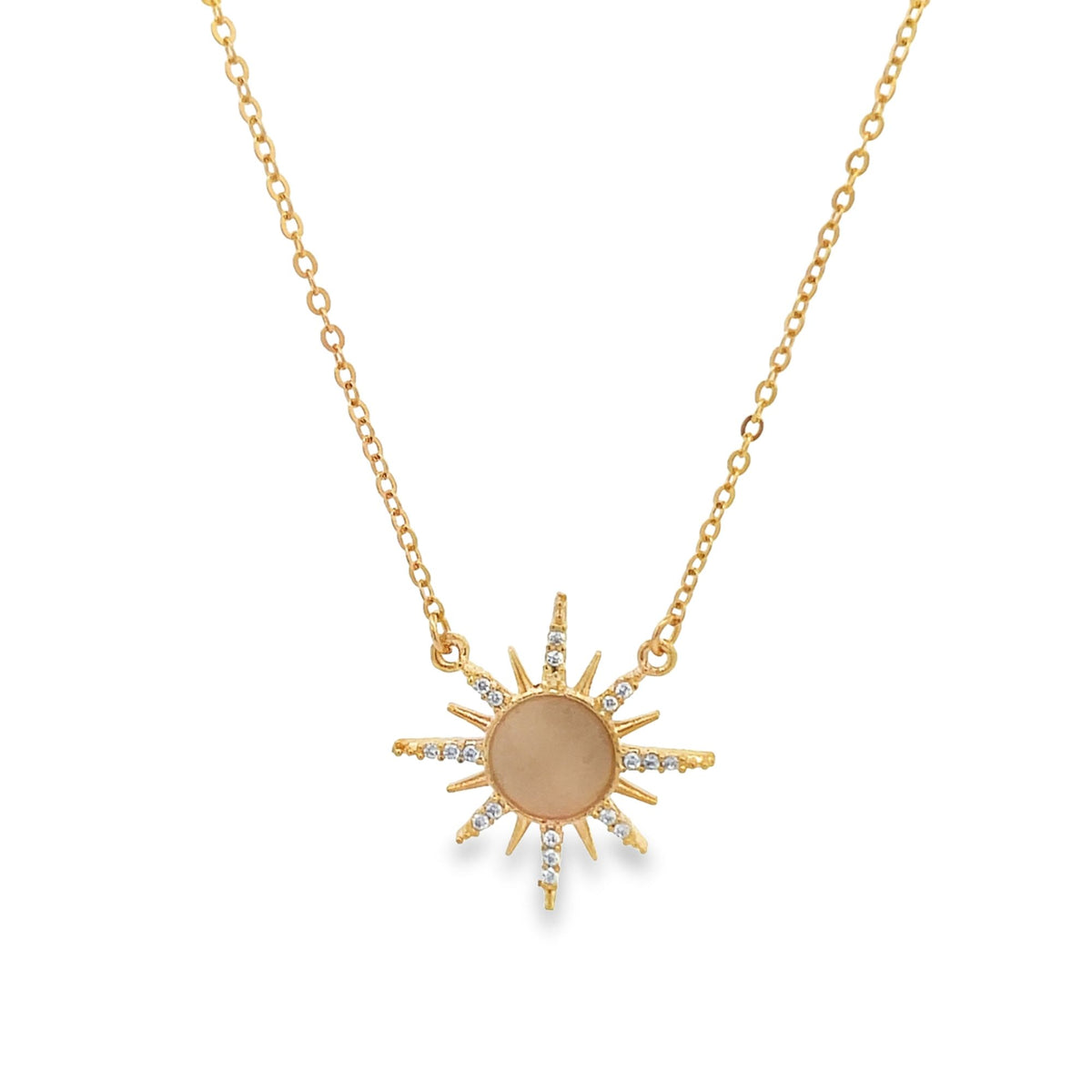 A delicate gold chain necklace features a radiant sunburst pendant accented with sparkling diamonds and a smooth center stone.