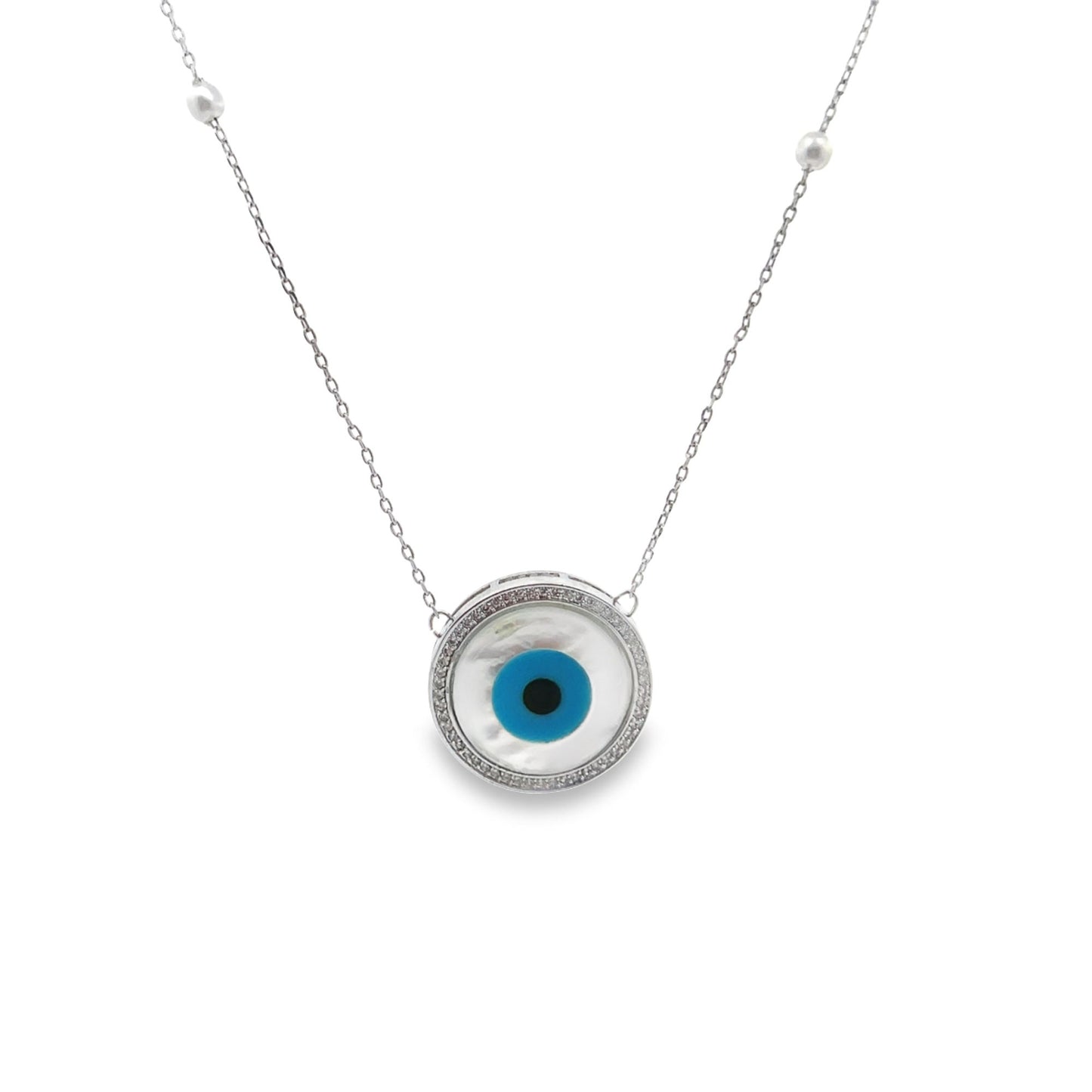 A delicate silver chain necklace features a round evil eye pendant with a mother-of-pearl center and a sparkling diamond halo.