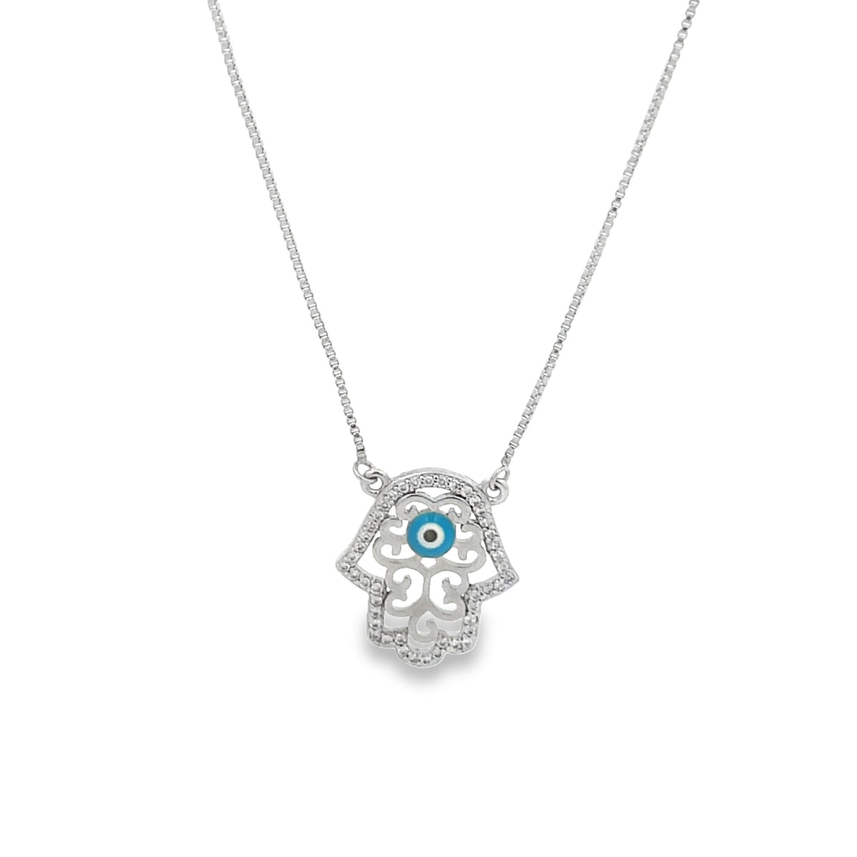 A silver Hamsa hand necklace features a blue evil eye centerpiece and sparkling pavé diamond accents.