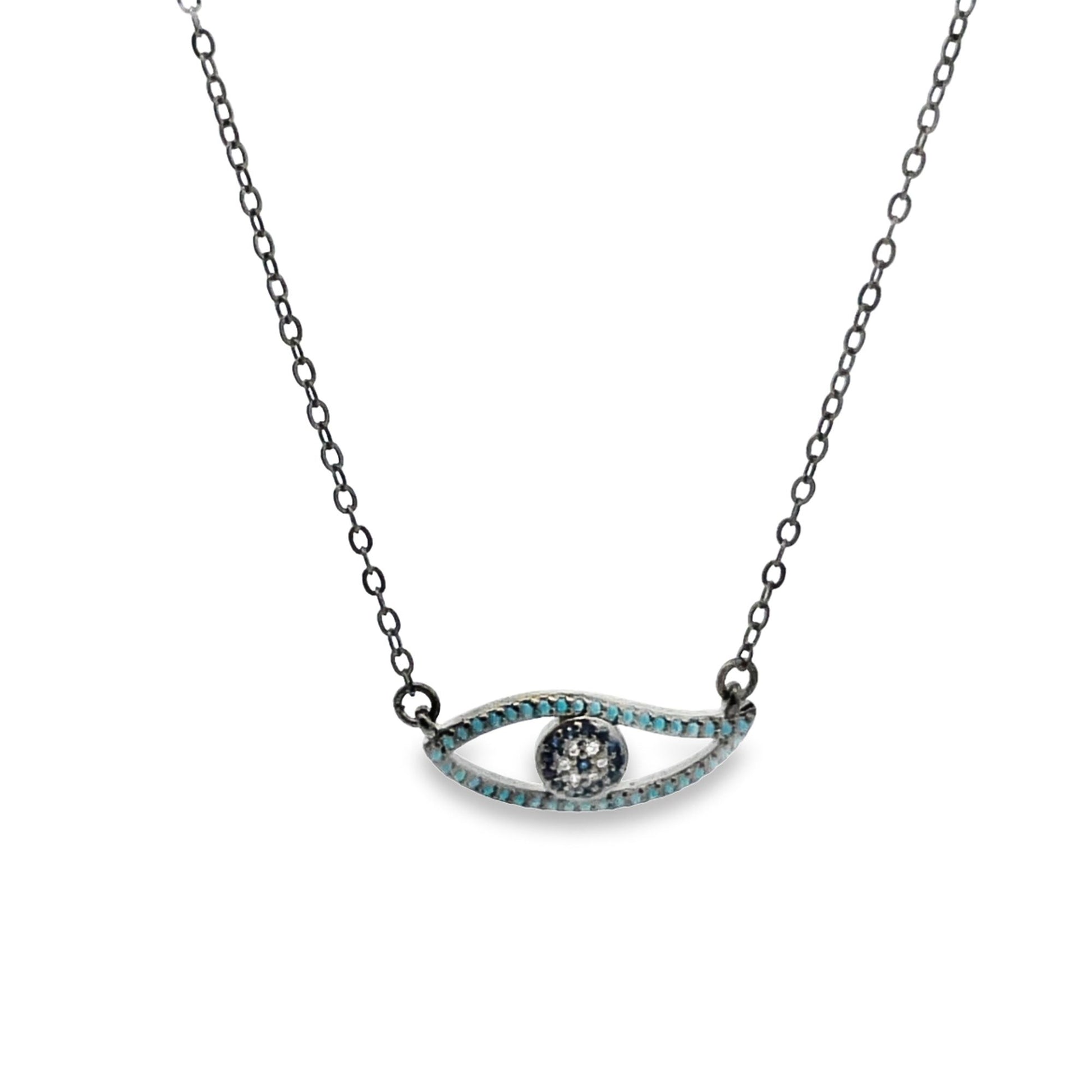 A delicate silver evil eye pendant necklace features a turquoise-accented eye motif hanging from a fine chain.