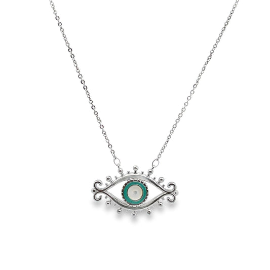 A delicate silver necklace features an ornate evil eye pendant with vibrant turquoise and white enamel details against a white background.
