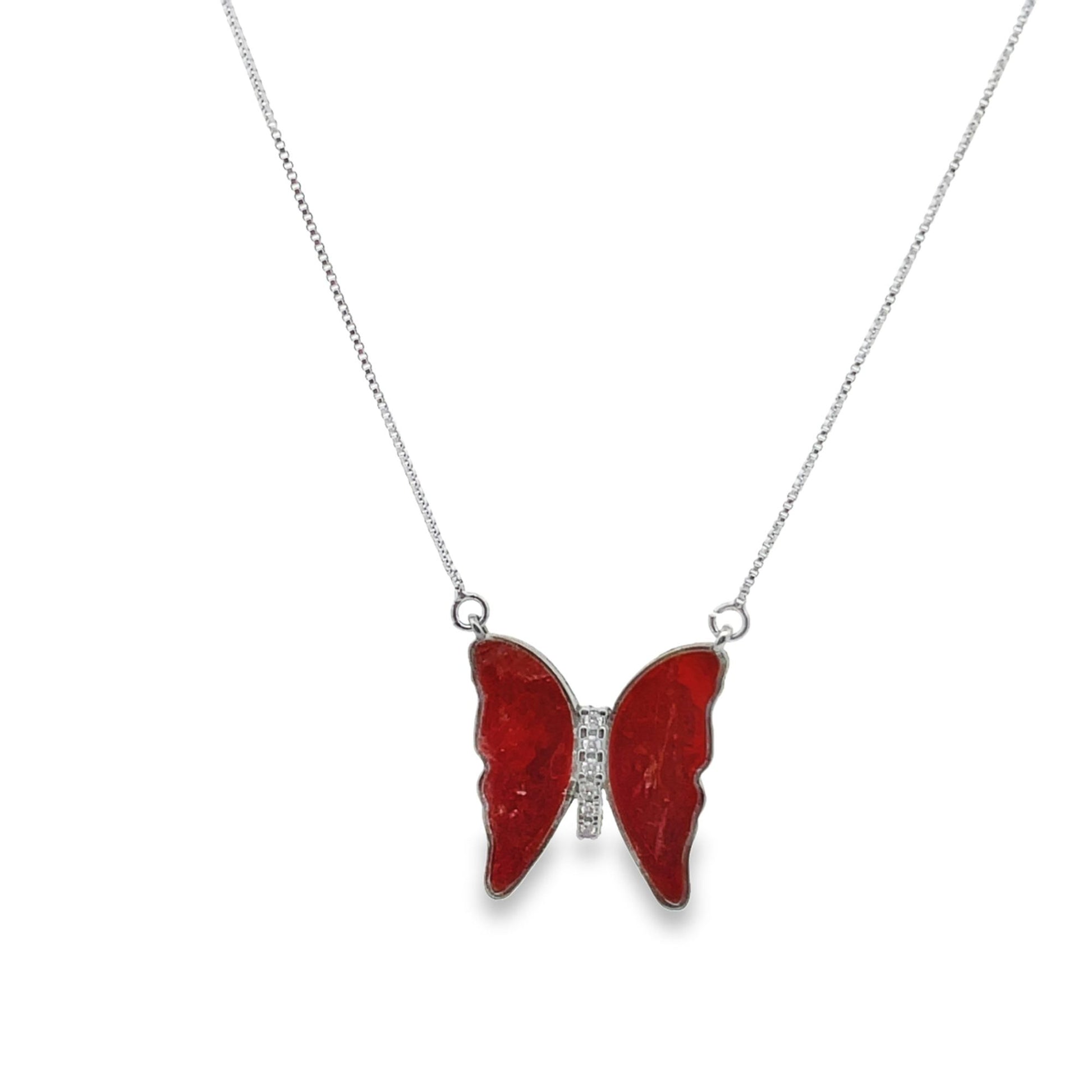 A delicate silver chain necklace features a vibrant red butterfly pendant with a sparkling crystal body.