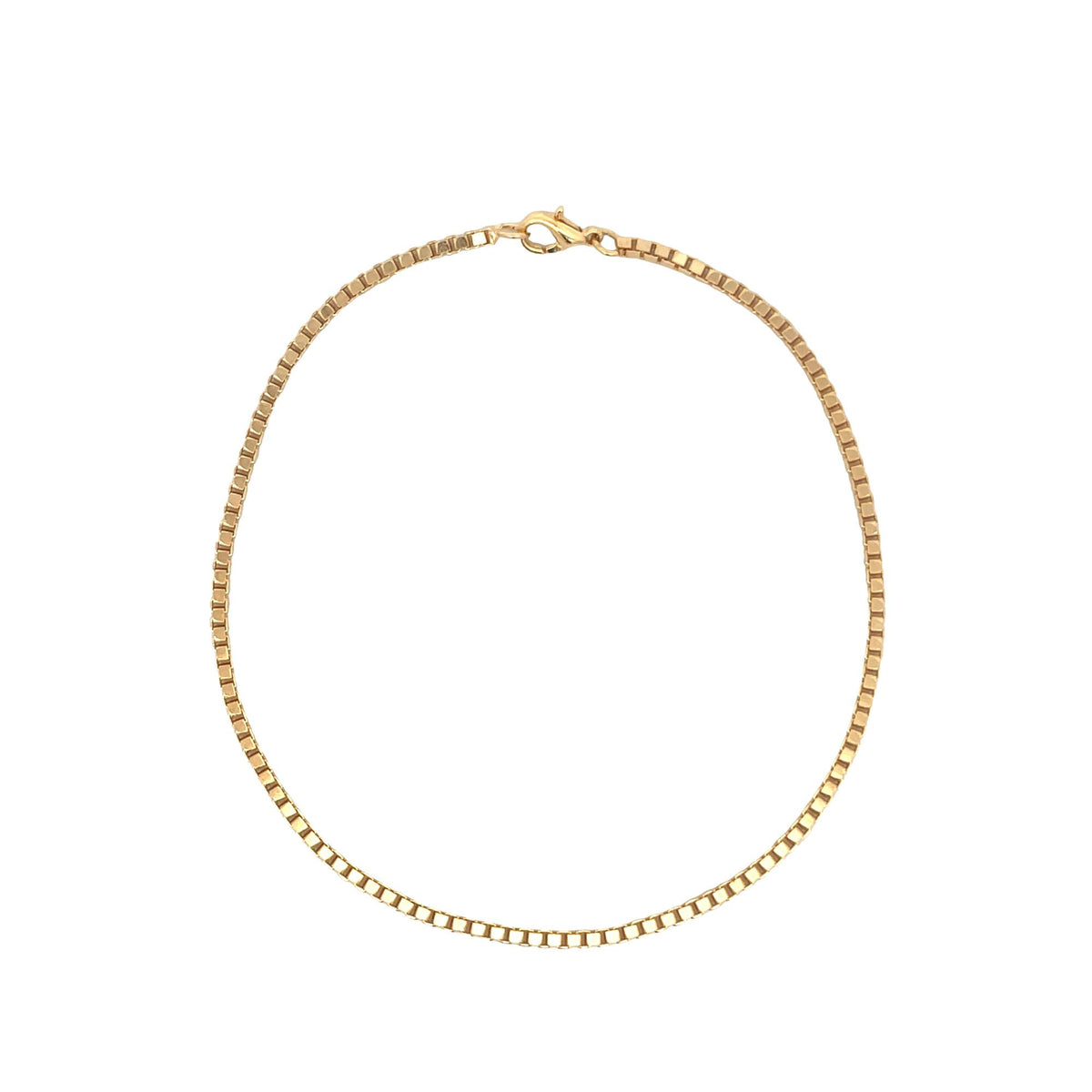 A delicate gold box chain necklace rests in a neat circle against a plain white background, highlighting its interlocking square links and secure clasp.