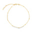 A delicate gold chain anklet adorned with evenly spaced small beads lies displayed against a clean white background.