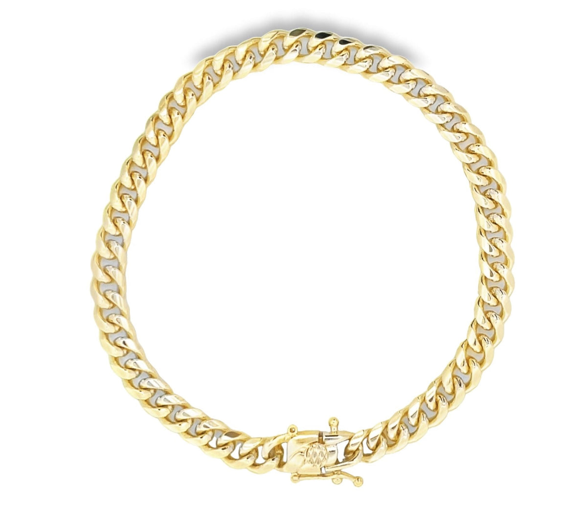 A thick gold Cuban link chain necklace lies arranged in a circle against a white background.