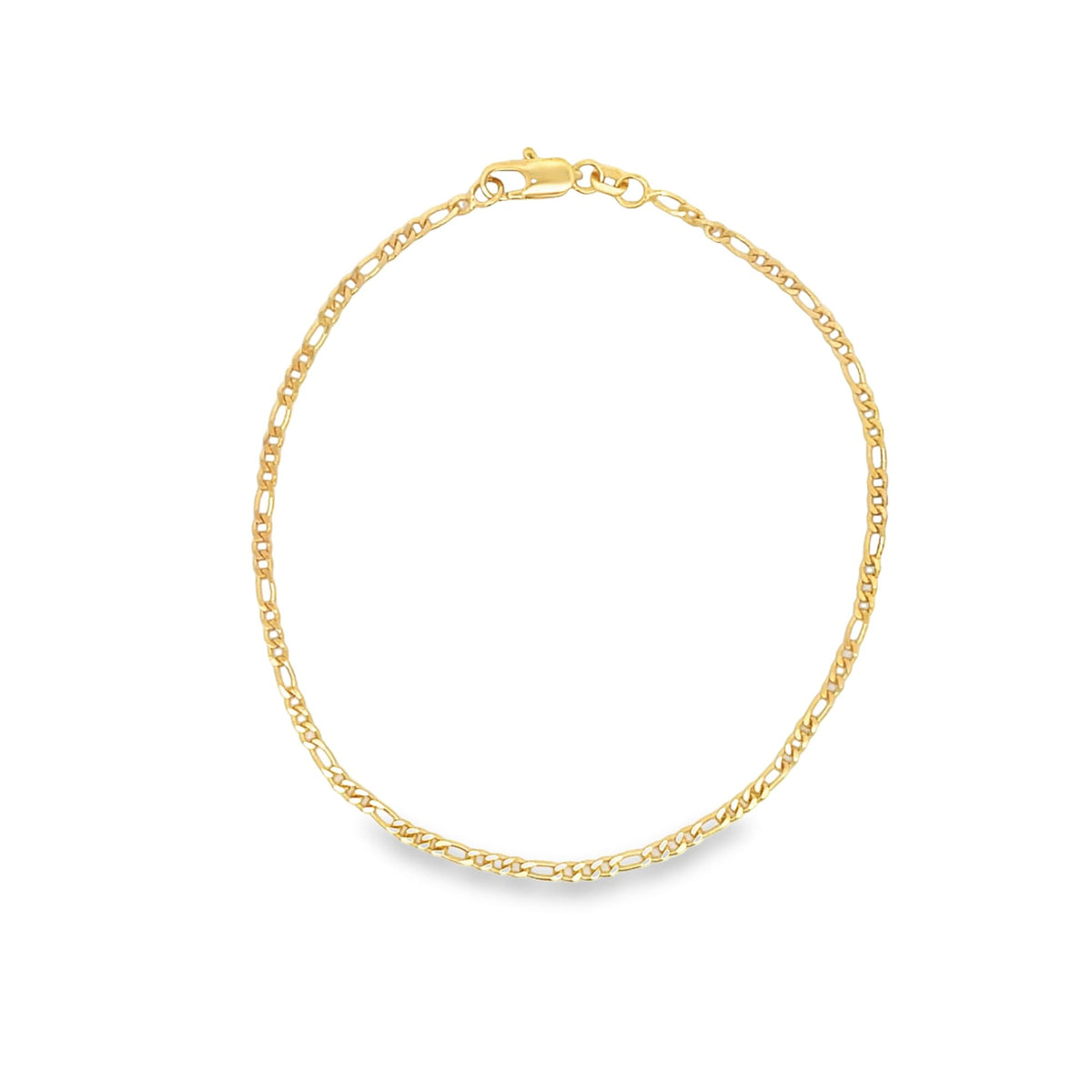 A delicate gold Figaro link chain bracelet rests in a circle on a clean white surface, showcasing its classic interlocking pattern and secure lobster clasp.