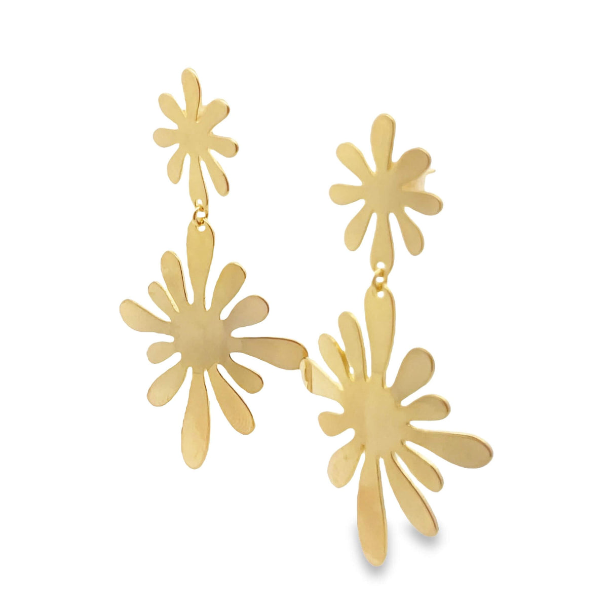 A pair of gold floral drop earrings hangs against a clean white background, showcasing their playful, abstract flower-shaped design.