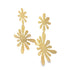 A pair of gold floral drop earrings hangs against a clean white background, showcasing their playful, abstract flower-shaped design.