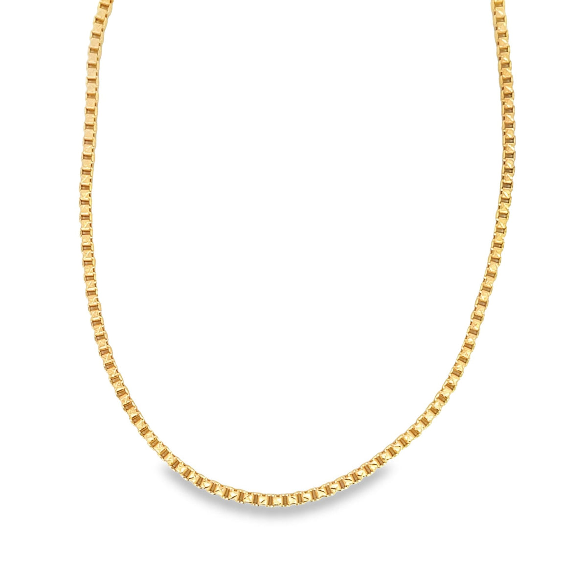 A shiny gold box chain necklace curves gracefully against a plain white background.
