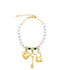 A gold charm bracelet features a strand of white beads accented with evil eye beads and dangling gold heart, key, and lock charms.