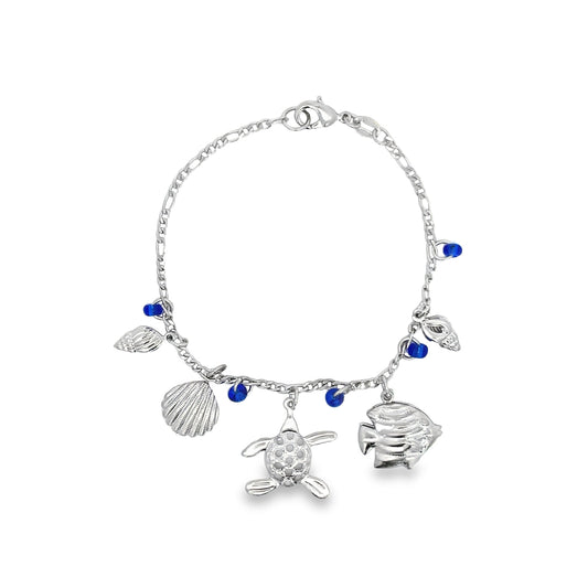 A silver charm bracelet features sea-themed charms including a turtle, fish, seashells, and blue glass beads against a white background.
