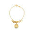 A delicate gold charm bracelet displays a round Libra zodiac pendant suspended among a cluster of small golden rings.