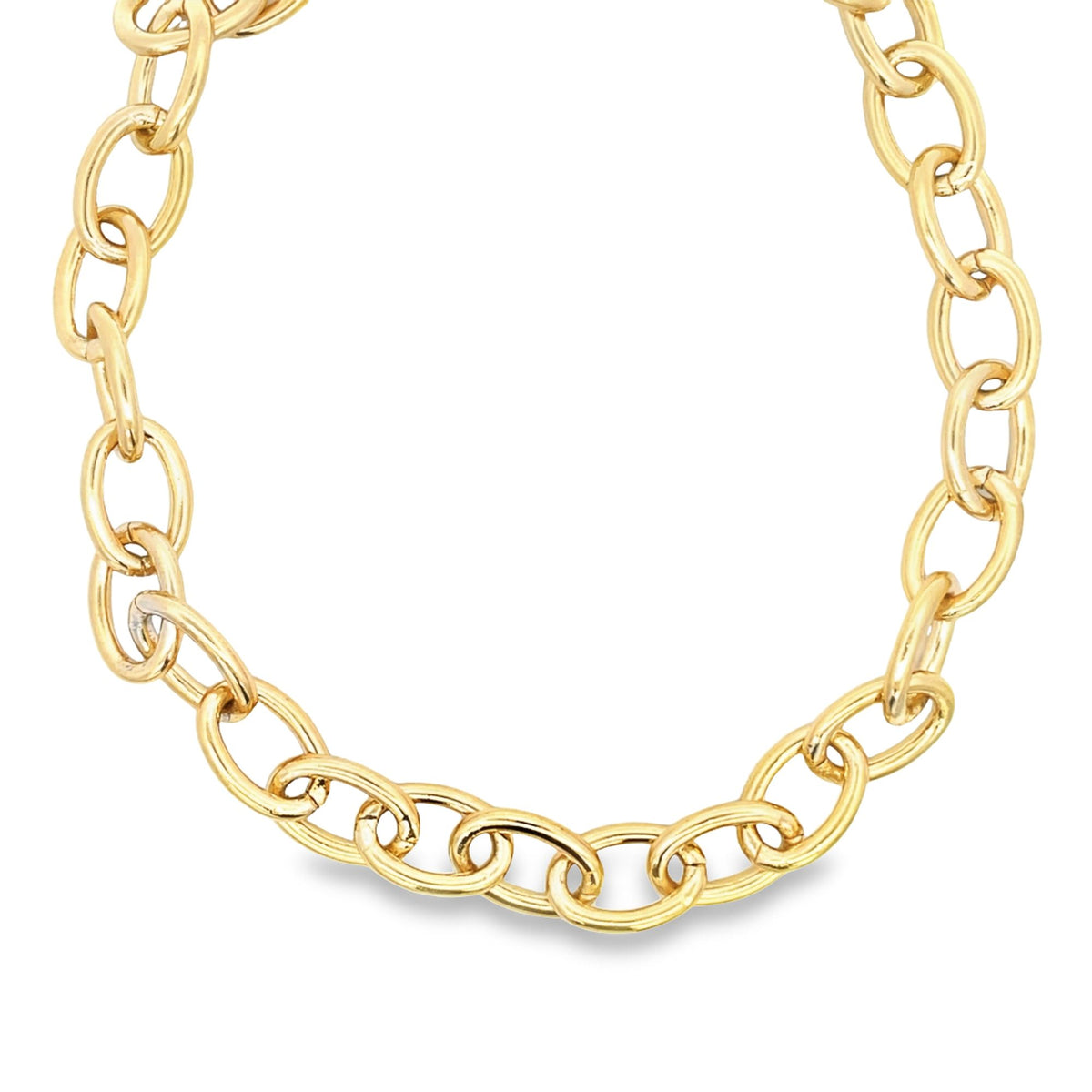 A thick, polished gold chain necklace curves gracefully against a plain white background.