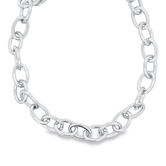 A polished sterling silver cable chain necklace curves gracefully against a clean white background.