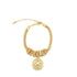 A gold mesh link charm bracelet features a dangling circular coin pendant with a detailed lion head engraving.