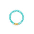 A vibrant turquoise pearl beaded ring features two polished gold accent beads at the bottom.