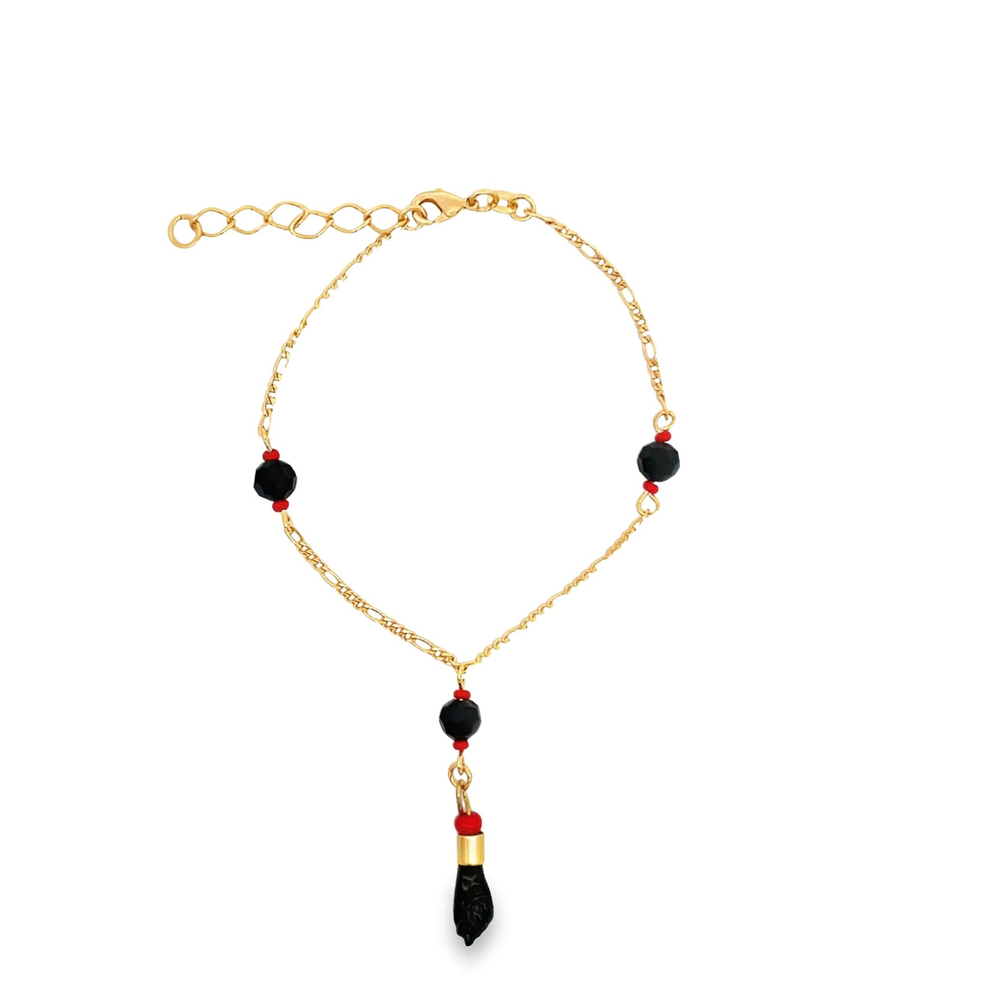 A gold charm bracelet features black and red beads along a delicate chain against a white background.