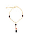 A gold charm bracelet features black and red beads along a delicate chain against a white background.