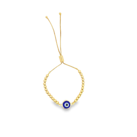 A gold slider bracelet features a central blue evil eye charm and delicate bead accents on a white background.