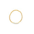 A delicate gold beaded stretch bracelet features a subtle cluster of white seed beads at the bottom against a plain white background.