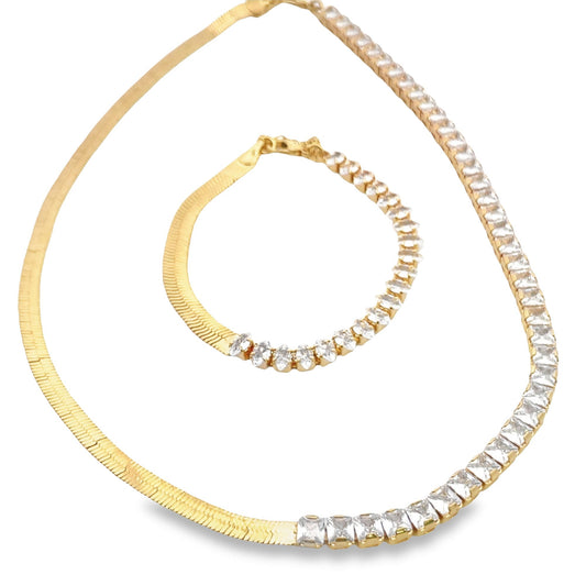 A matching gold jewelry set displays a split design featuring a herringbone chain paired with sparkling cubic zirconia stones on both the necklace and bracelet.